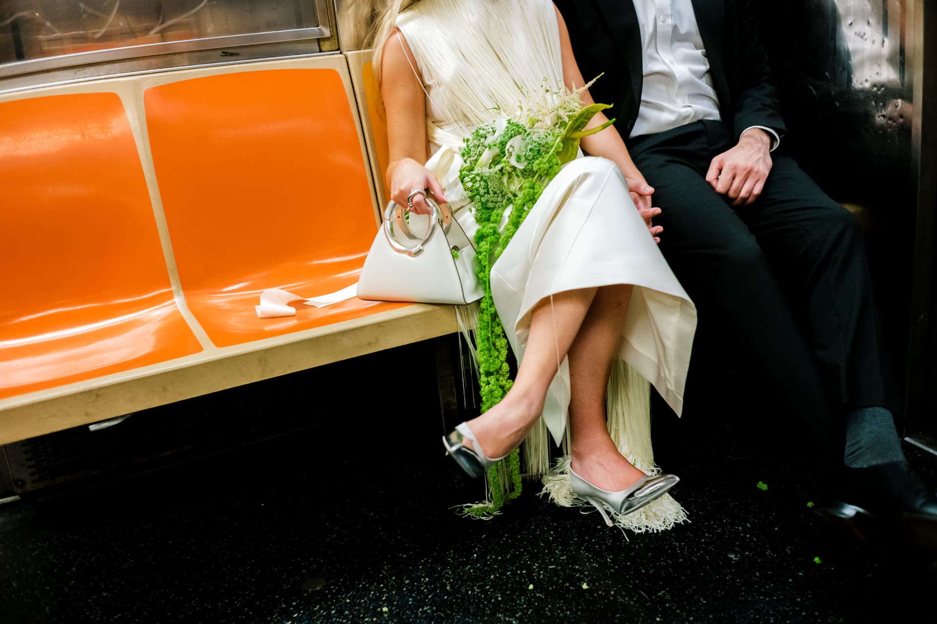 Bride and groom on the New York City subway with a green cascading bouquet